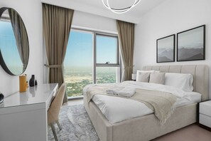 Ein modernes Hotelzimmer mit einem großen Bett, einem Schreibtisch und Blick auf die Stadt.