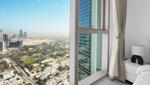 A high-rise hotel room with a large window overlooking a cityscape. - 1BR Retreat Near Burj Khalifa (Dubai)