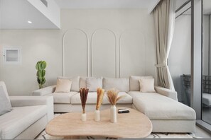 Un salon moderne avec un canapé d’angle, une table basse et des vases décoratifs.