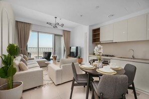 Ein modernes Wohnzimmer mit einer Sofagarnitur, einem Esstisch und einer Küchenzeile.
