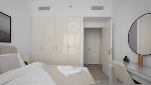 A modern hotel room with a large bed, a wardrobe, a mirror, and a door leading to another room. - 1BR Retreat Near Burj Khalifa (Dubai)
