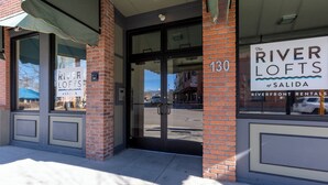Het uiterlijk van Riverfront Rentals op nummer 130, met een bakstenen gevel, grote ramen en een helder uitzicht op de straat.