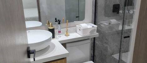 Chuveiro, toalhas de banho, sabonete, papel higiênico