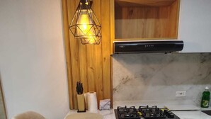 A modern kitchen with a marble countertop, a gas stove, and a built-in oven. - New apartment well located in a 4 floor brand new with all the comforts. (Barranquilla)