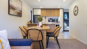 Una cocina moderna con armarios de madera, un refrigerador de acero inoxidable y una ventana con vista a la calle.