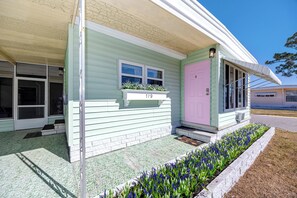 A single-story house with a number 179 sign above the door, a pink door, and a small porch area with a flower bed. - MINT Julip - Amazing 40+ Community - Newly Updated 2 bed/2 bath single family (Largo)