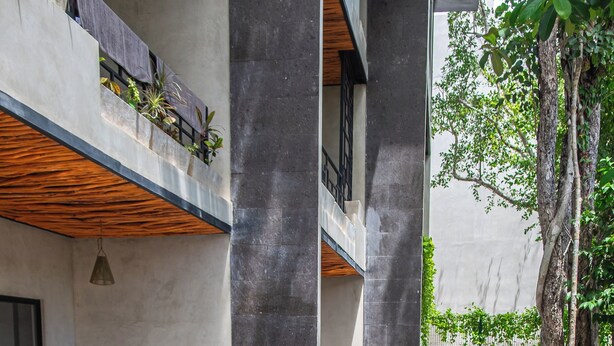 A modern outdoor pool area with a wooden deck, surrounded by concrete walls and plants. - Luxury Penthouse in Tulum with Private Rooftop (Tulum)