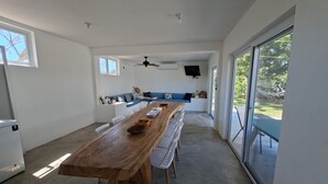 Una cocina moderna con una amplia mesa de madera, sillas blancas y un sofá azul.