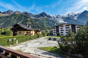Ein Bergresort mit Chalet-Gebäuden, einer gepflasterten Auffahrt und schneebedeckten Gipfeln im Hintergrund.