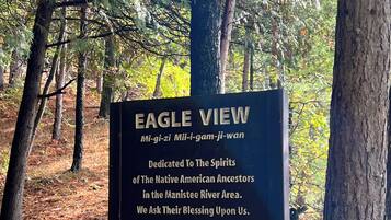 A sign dedicated to Native American ancestors in a forested area.