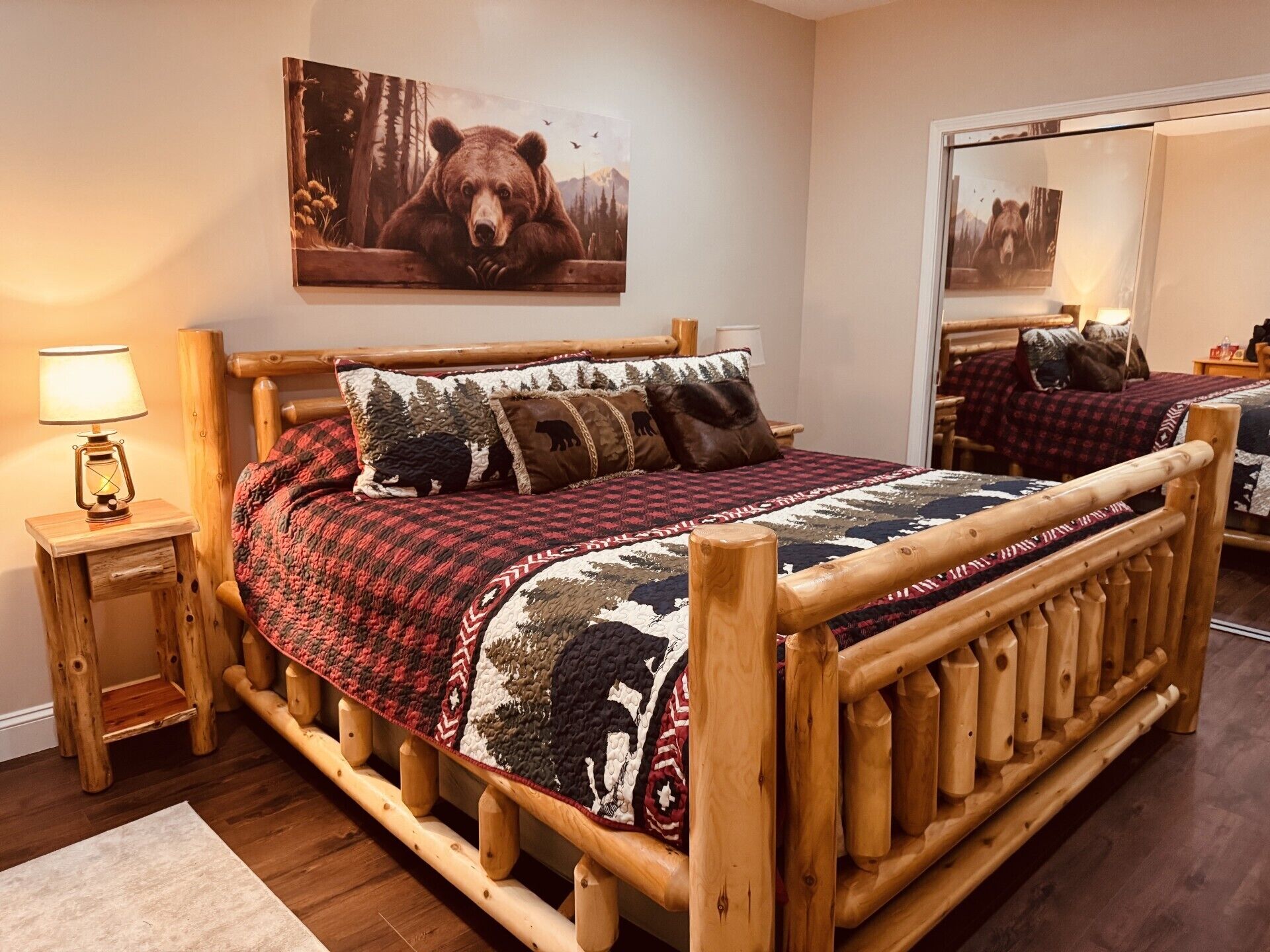 Ein hölzernes Bett mit einer Steudecke, einer Nachttischlampe und einem Teddy-Motiv-Kissen.