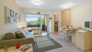 Een modern appartement met een woonruimte, kitchenette en balkon.