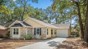 A two-story house with a stone facade, a garage, and a front yard with trees. - Coastal Comfort- Intracoastal Waterway Escape (Murrells Inlet)