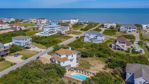 An aerial view of a coastal residential area with houses, roads, and a beach. - Absolute Paradise -  4 BR Oceanside Home w/Private Pool, 105 Yards to Beach Access (Southern Shores)