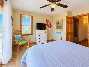 A bedroom with a bed, a television, a chair, a dresser, and a ceiling fan. - Seven Seas - 4 BR Oceanfront Home w/Private Pool & Ocean Views (Southern Shores)