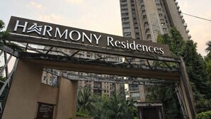 Segnaletica per Harmony Residences, con un alto edificio sullo sfondo.