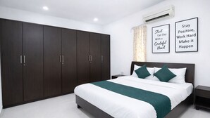 Una camera da letto moderna con un letto grande, un armadio in legno scuro e decorazioni motivazionali al muro.
