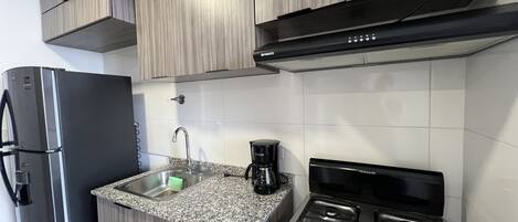 Departamento ejecutivo, balcón, vista a la ciudad | Cocina privada | Cafetera y tetera y comedor