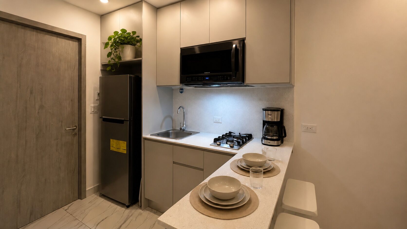 A compact kitchen with a refrigerator, microwave, stove, and coffee maker.