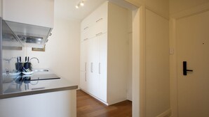 Una cocina moderna con armarios blancos, una campana de acero inoxidable y piso de madera.