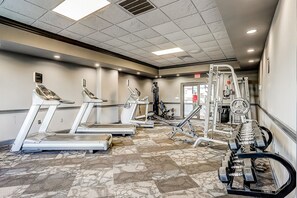 Ein Fitnessstudio mit Laufbändern, Crosstrainern und Gewichten.