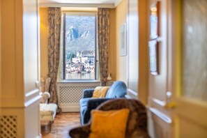 A hotel corridor with a view of a mountainous town through a window. - Casa Orta apartment with lake view (Orta San Giulio)