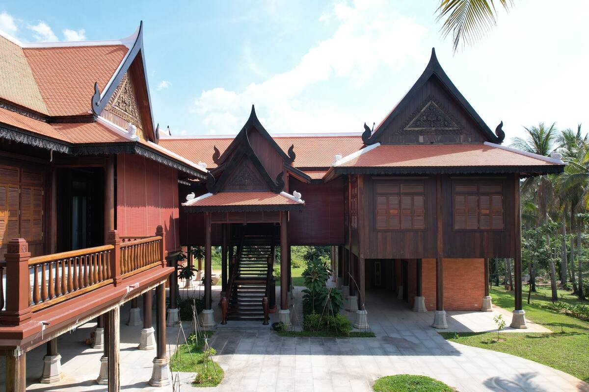 A traditional wooden building with a covered walkway and a staircase leading to an upper level.
