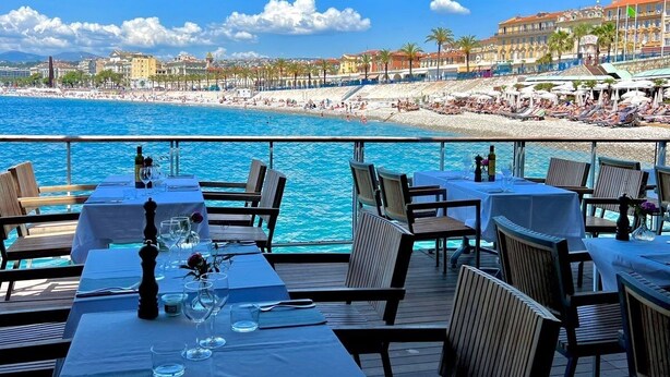 En restaurang vid havet med uteservering och utsikt över stranden och havet.