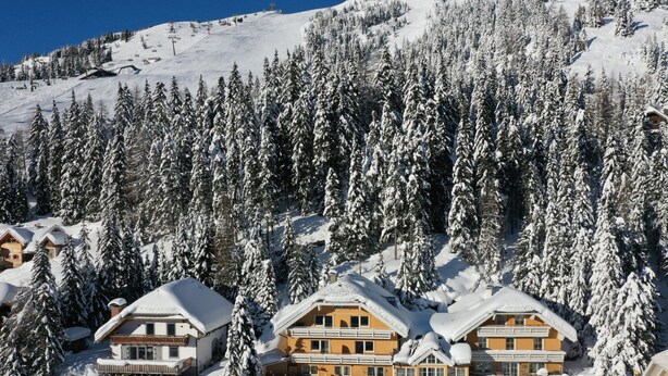 A snow-covered lodge with multiple buildings, surrounded by dense evergreen trees. - Katschberg 26 by Interhome (Sankt Michael im Lungau)