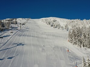 A snowy ski slope with ski lifts and trees. - Katschberg 25 by Interhome (Sankt Michael im Lungau)