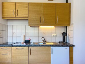 A kitchen with wooden cabinets, a stainless steel sink, and a Bosch dishwasher. - Katschberg 23 by Interhome (Sankt Michael im Lungau)