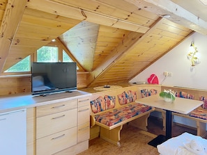 A cozy cabin interior with a wooden ceiling, a television, a bench, and a table. - Katschberg 20 by Interhome (Sankt Michael im Lungau)