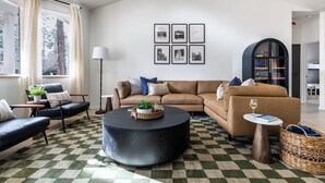 A modern living room with a checkered floor, a sofa set, a coffee table, and framed pictures on the wall. - Flagstaff Retreat with Hot Tub (Flagstaff)
