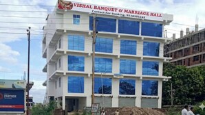 A multi-story building with a sign for Vishal Banquet & Marriage Hall. - Spacious Stay Near Bodh Gaya – AC Rooms, Lawn & Banquet Hall (Bodh Gaya)