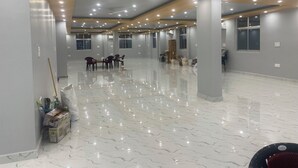 A spacious hotel room with a polished marble floor, multiple ceiling lights, and a large window. - Spacious Stay Near Bodh Gaya – AC Rooms, Lawn & Banquet Hall (Bodh Gaya)