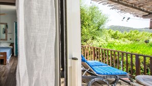 Un balcone con vista su un giardino rigoglioso e un pontile in legno.