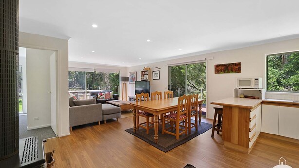 A spacious living area with a dining table, sofa, and a kitchen area with a microwave. - The Ash, Sandy Point (Sandy Point)