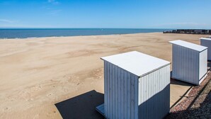 Una playa con cabañas blancas y un cielo azul despejado.