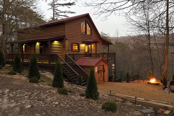 A log cabin with a porch, a fire pit, and a staircase leading to the entrance. - Hot Tub + Mtn Views: Peaceful Blue Ridge Retreat! (Blue Ridge)