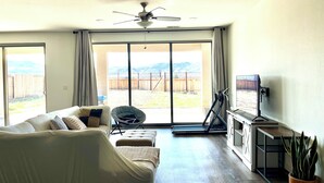 A living room with a sofa, a chair, a TV, and a plant. - Quiet place (Spanish Springs)