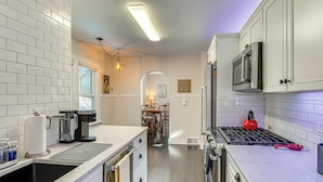 A kitchen with white cabinets, a stainless steel refrigerator, a microwave, and a gas stove. - Walk to Fox River Grove Train Station + Hot Tub! (Fox River Grove)