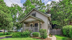 A single-story house with a front porch, a small garden, and a wooden fence. - Walk to Fox River Grove Train Station + Hot Tub! (Fox River Grove)