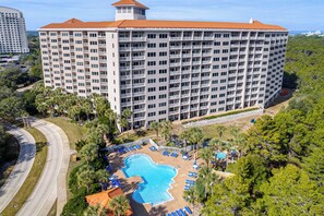 A high-rise hotel with multiple balconies, a swimming pool, and a view of the surrounding landscape. - Ocean-View Balcony! Tops'l Beach Resort Condo (Miramar Beach)