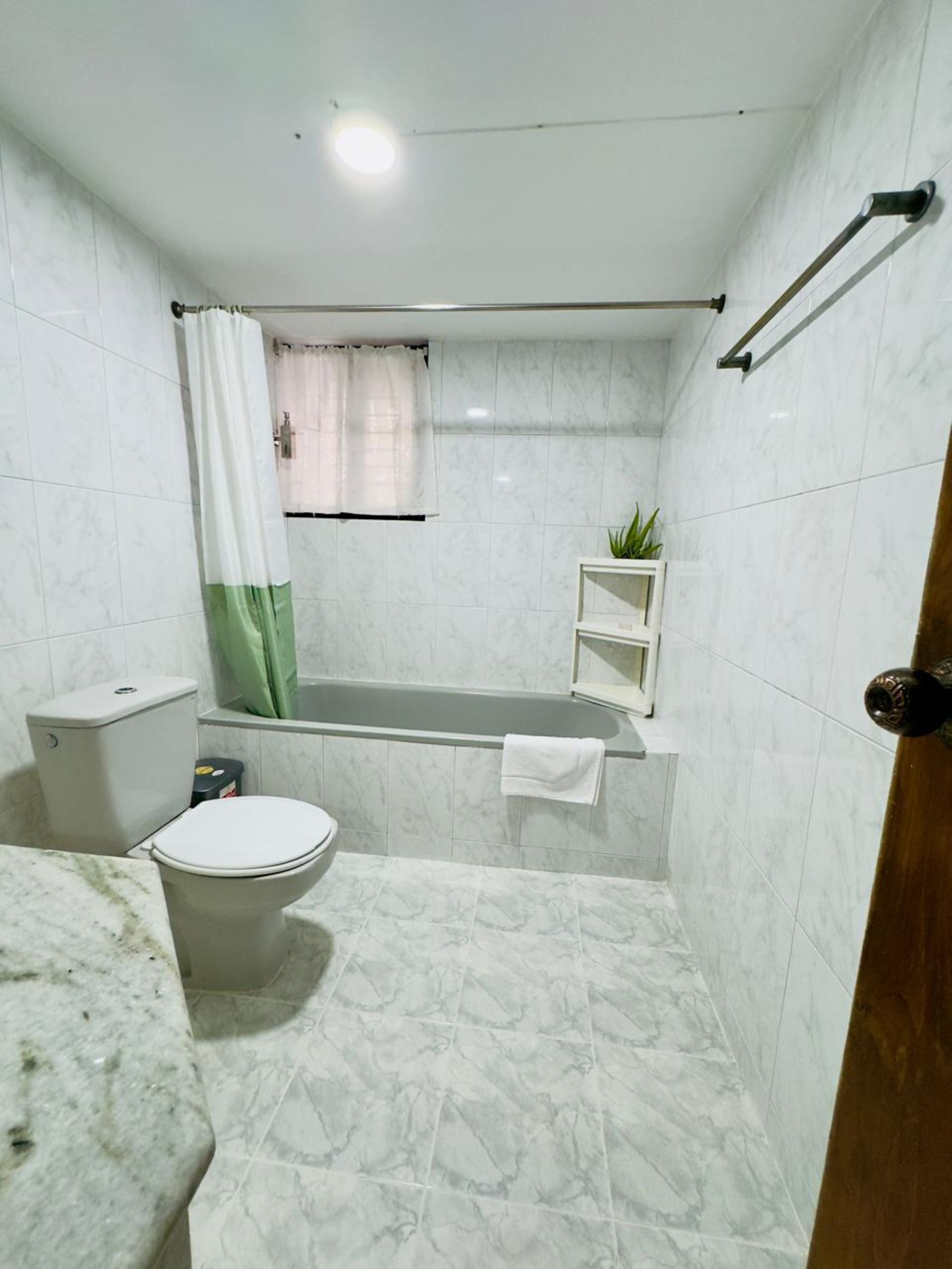 Un baño con inodoro, bañera y cortina de ducha.