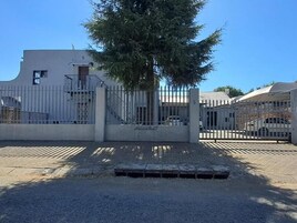 Un estacionamiento cerrado con un edificio al fondo.