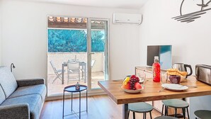 Eine moderne Küche mit Essbereich, einer Couch und Blick ins Freie.
