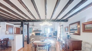A spacious living area with a dining table, chairs, and a kitchen in the background. - La Maisonnette by Interhome (Le Val)