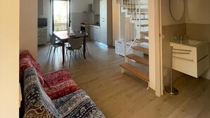 Un appartement moderne comprenant un salon, une cuisine et un escalier.