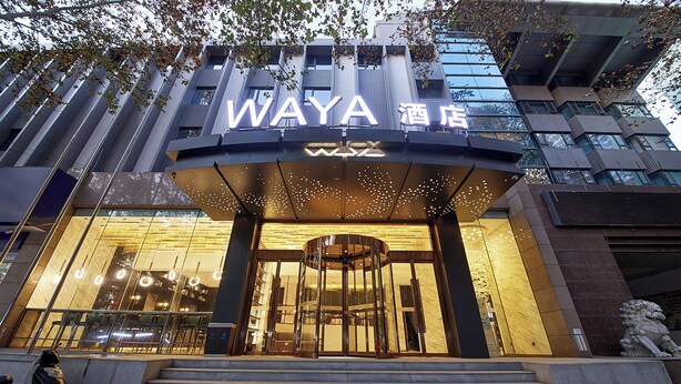 The exterior of the WAYA Hotel with a modern design, featuring a prominent entrance and illuminated signage. - Xi'an waya hotel (Xi'an)