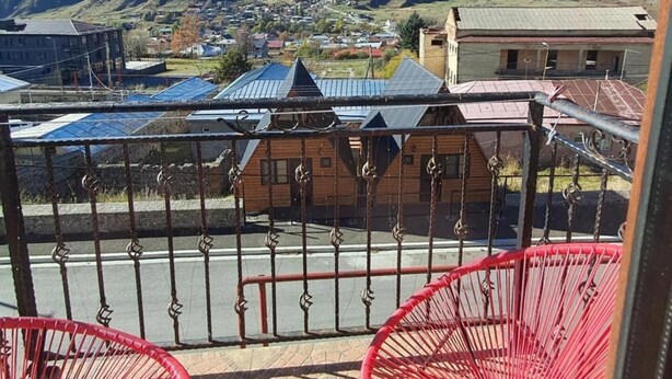 Un balcon offrant une vue sur une chaîne de montagnes et sur une ville située en contrebas.